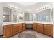 Well-lit bathroom with double sinks, custom wood cabinets, and vanity area at 2925 E Cathy E Dr, Gilbert, AZ 85296