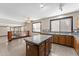 Open-concept kitchen with granite island, modern appliances, tile floor, and light wood cabinetry at 2925 E Cathy E Dr, Gilbert, AZ 85296