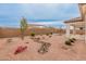 An open backyard features desert landscaping, including rock beds, trees and an open patio at 3287 N 197Th Ln, Buckeye, AZ 85396