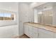 Bright bathroom with double granite vanity, large mirror, and a view to the main bedroom at 3287 N 197Th Ln, Buckeye, AZ 85396