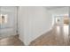 Hallway view featuring wood-look tile, crisp white walls leading to various rooms with abundant light at 3287 N 197Th Ln, Buckeye, AZ 85396