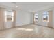 Bright, airy living room boasting natural light, wood-look tile flooring, neutral paint, and modern recessed lighting at 3287 N 197Th Ln, Buckeye, AZ 85396