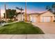 Elegant home with a three car garage, circular entryway, palm trees, and green lawn at 3441 S Camellia Pl, Chandler, AZ 85248