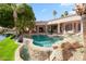 Sparkling pool with stone accents and a waterfall adds elegance to the outdoor living space at 3441 S Camellia Pl, Chandler, AZ 85248