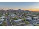 Expansive aerial view showcases the single-story home's location with mountain views and mature trees at 3531 E Onyx Ave, Phoenix, AZ 85028