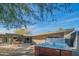 Backyard featuring a hot tub, spacious patio with colorful seating, and mature trees at 3531 E Onyx Ave, Phoenix, AZ 85028