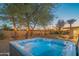 Backyard hot tub area with lush desert landscaping and outdoor lighting for ultimate relaxation at 3531 E Onyx Ave, Phoenix, AZ 85028