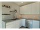 Chic kitchen featuring white cabinetry, stainless appliances, and stylish backsplash with floating shelving at 3531 E Onyx Ave, Phoenix, AZ 85028