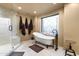 A luxurious bathroom featuring a freestanding tub, glass enclosed shower, and decorative window at 40947 N 107Th Pl, Scottsdale, AZ 85262