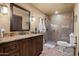 Stylish bathroom featuring a granite vanity, wood cabinetry, and walk-in shower at 40947 N 107Th Pl, Scottsdale, AZ 85262