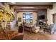 Inviting living room featuring a stone fireplace, wood beams, and scenic views of the mountain landscape at 40947 N 107Th Pl, Scottsdale, AZ 85262