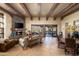 Inviting living room showcases a stone fireplace, wood-beamed ceilings, and desert views through large sliding glass doors at 40947 N 107Th Pl, Scottsdale, AZ 85262