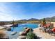 Infinity pool with stone accents, desert landscape, golf course and mountain views at 40947 N 107Th Pl, Scottsdale, AZ 85262