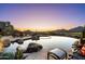 Relaxing backyard pool with a stunning desert view as the sun sets on the horizon at 40947 N 107Th Pl, Scottsdale, AZ 85262