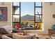 Living room view showcases desert landscape with distant mountain, pool, and outdoor seating at 40947 N 107Th Pl, Scottsdale, AZ 85262