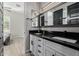 Stylish bathroom with dual sinks, black countertops, and neutral tiling at 4191 S Emerald Dr, Chandler, AZ 85249