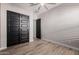 Bedroom features wood-look tile, neutral walls, and black closet doors at 4191 S Emerald Dr, Chandler, AZ 85249