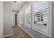 Hallway featuring wood-look tile flooring and white shutters overlooking the outdoor patio at 4191 S Emerald Dr, Chandler, AZ 85249