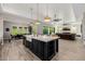 Kitchen island with a farmhouse sink and black faucet, connecting seamlessly to dining and living areas at 4191 S Emerald Dr, Chandler, AZ 85249