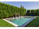 Relaxing pool area featuring a tranquil fountain feature and surrounded by mature privacy hedges and artificial turf at 4191 S Emerald Dr, Chandler, AZ 85249