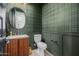 Elegant powder room with decorative green wallpaper, custom vanity, stylish fixtures and a modern mirror at 4191 S Emerald Dr, Chandler, AZ 85249