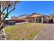 Spacious backyard with a pergola-covered patio, a hot tub, gravel landscaping, and a glimpse of the home's exterior at 42297 W Lunar St, Maricopa, AZ 85138