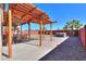 Backyard featuring a covered patio, dining set, a hot tub, and desert landscaping in a private setting at 42297 W Lunar St, Maricopa, AZ 85138