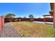 Expansive backyard featuring a hot tub, a perimeter of gravel, and a mix of green and dormant grass at 42297 W Lunar St, Maricopa, AZ 85138