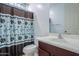 Bathroom featuring a floral-patterned shower curtain, a white sink, and a modern faucet at 42297 W Lunar St, Maricopa, AZ 85138