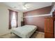 Comfortable bedroom features a ceiling fan, large window, neutral carpeting, and a warm two-tone paint scheme at 42297 W Lunar St, Maricopa, AZ 85138