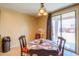 Cozy dining area with a view to the backyard through a large window, and an ornate chandelier at 42297 W Lunar St, Maricopa, AZ 85138