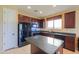 Kitchen boasts black appliances, dark wood cabinetry, and a tile backsplash at 42297 W Lunar St, Maricopa, AZ 85138