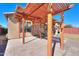 Covered patio area featuring a wooden pergola, paved flooring, and outdoor seating for relaxation at 42297 W Lunar St, Maricopa, AZ 85138