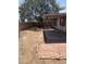 Backyard featuring dirt and covered patio with pillars and mature trees at 4927 W Golden Ln, Glendale, AZ 85302