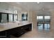 Large bathroom with double sinks, stone tile, large mirror, and doorway leading to bedroom at 4959 E Red Rock Dr, Phoenix, AZ 85018