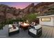 Outdoor deck featuring a fire pit, comfortable seating, and stunning mountain views at twilight at 4959 E Red Rock Dr, Phoenix, AZ 85018