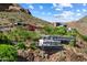 Exterior shot of a modern home nestled into the mountainside with lush landscaping at 4959 E Red Rock Dr, Phoenix, AZ 85018