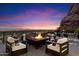 Outdoor deck featuring a cozy firepit and seating area with stunning mountain views and city lights at 4959 E Red Rock Dr, Phoenix, AZ 85018