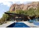 Backyard pool area with covered seating, poolside lounges, and mountain views at 4959 E Red Rock Dr, Phoenix, AZ 85018