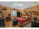 Cozy bedroom showcasing a comfortable bed with a red plaid comforter, complemented by eclectic decor and ample natural light at 5848 W Gelding Dr, Glendale, AZ 85306