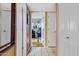 Bright hallway with white tile floor leads to a room with a desk, creating a functional and welcoming transition space at 5848 W Gelding Dr, Glendale, AZ 85306