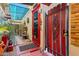 Charming patio with red brick, potted plants, colorful doors, and a delightful Beagle puppy at 5848 W Gelding Dr, Glendale, AZ 85306