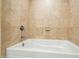 Close-up of neutral-tiled bathtub and shower with chrome fixtures in bright, updated bathroom at 7167 E Rancho Vista Dr # 4006, Scottsdale, AZ 85251