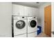 Well-lit laundry room featuring a front-loading washer and dryer set with ample white cabinet storage at 7167 E Rancho Vista Dr # 4006, Scottsdale, AZ 85251