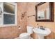 Cozy half-bathroom with pedestal sink and decorative mirror at 7520 S Jentilly Ln, Tempe, AZ 85283