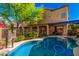 Backyard swimming pool and a covered patio area attached to a two-story home with mature trees and blue skies at 7520 S Jentilly Ln, Tempe, AZ 85283