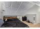 This loft bedroom has light colored floors, sleek black bedding, and an eye-catching paneled ceiling at 8055 E Thomas Rd # E106, Scottsdale, AZ 85251