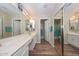 Well-lit bathroom with double sinks, vanity, and mirrored closet at 8444 W Rockwood Dr, Peoria, AZ 85382