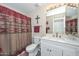 Cozy bathroom featuring a single sink vanity and rustic patterned shower curtain at 8444 W Rockwood Dr, Peoria, AZ 85382