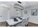 A dining room with modern lighting, a white table, and chairs with a unique black and white pattern at 8556 E Pecos Ln, Scottsdale, AZ 85250